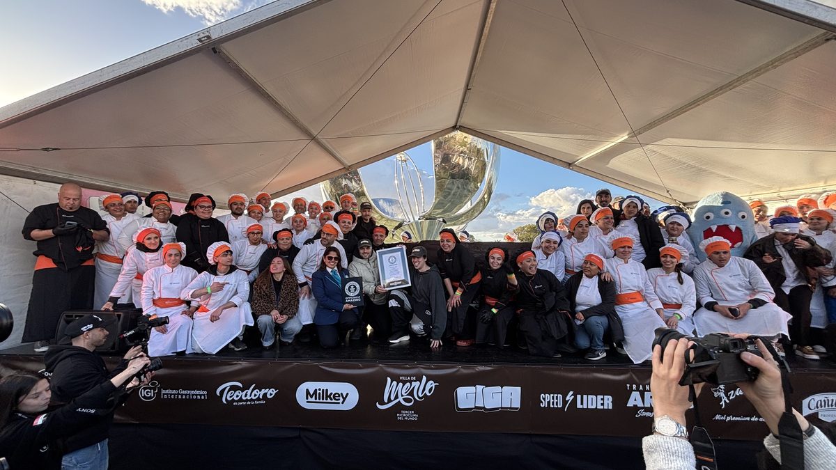 Foto grupal de profesores y alumnos del IGI junto al alfajor gigante al terminar la jornada del récord