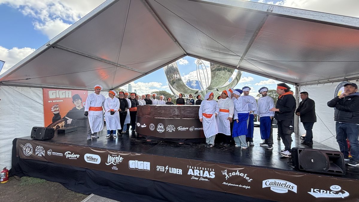 Alumnos y profesores del IGI con uniforme sobre el escenario del récord, junto al alfajor gigante