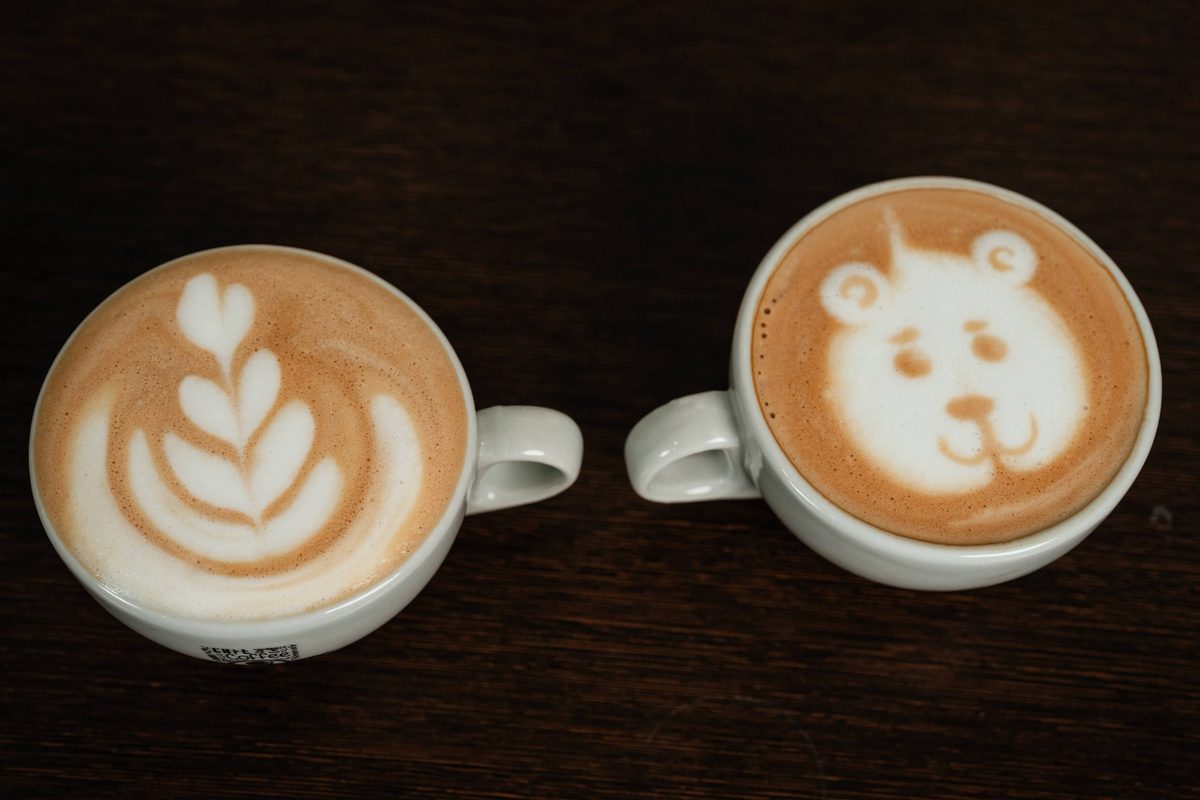 Dos tazas de café con diseños de arte latte