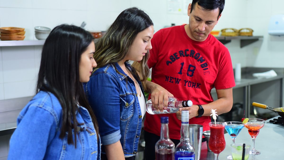 Instructor guiando a estudiantes durante una práctica de coctelería en IGI Asunción