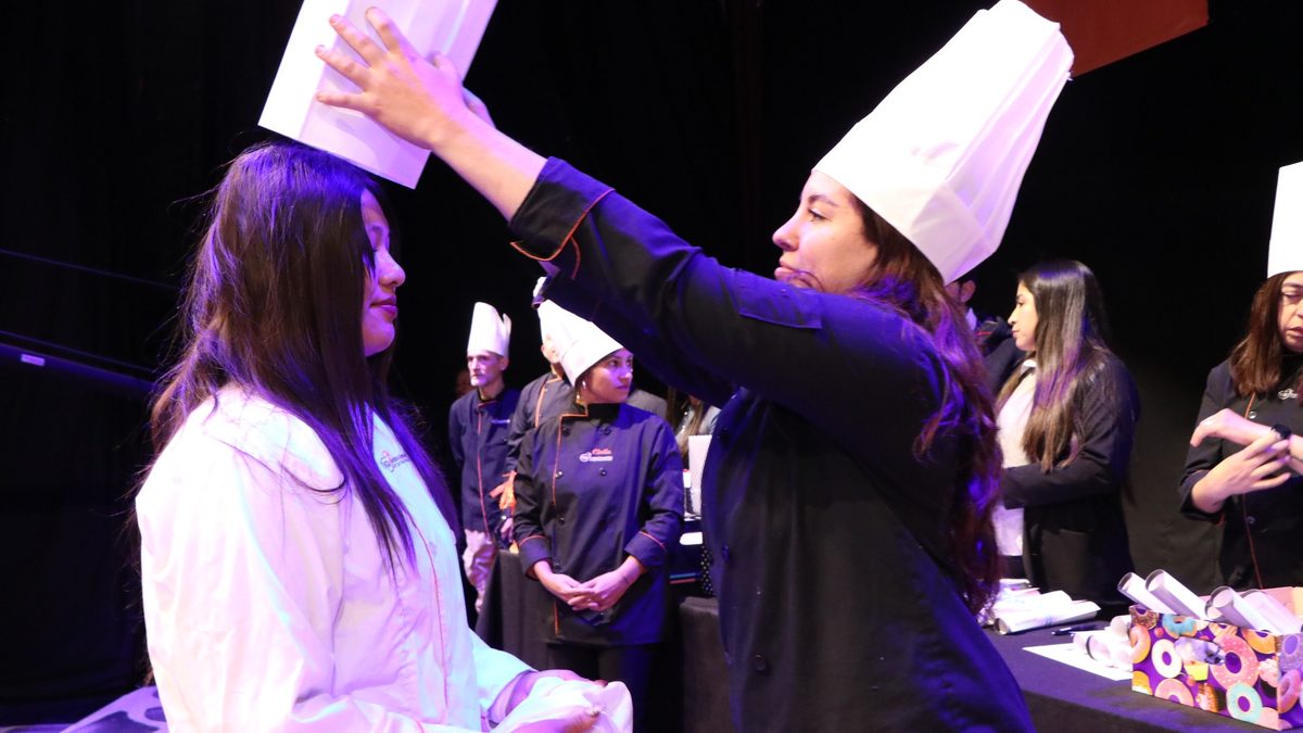 Egresado de IGI recibiendo su gorro durante el acto de colación