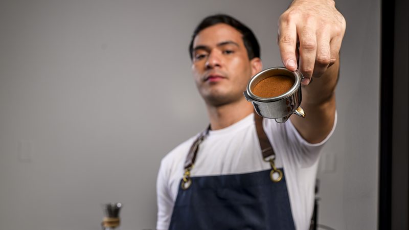 Barista de IGI mostrando una taza de café
