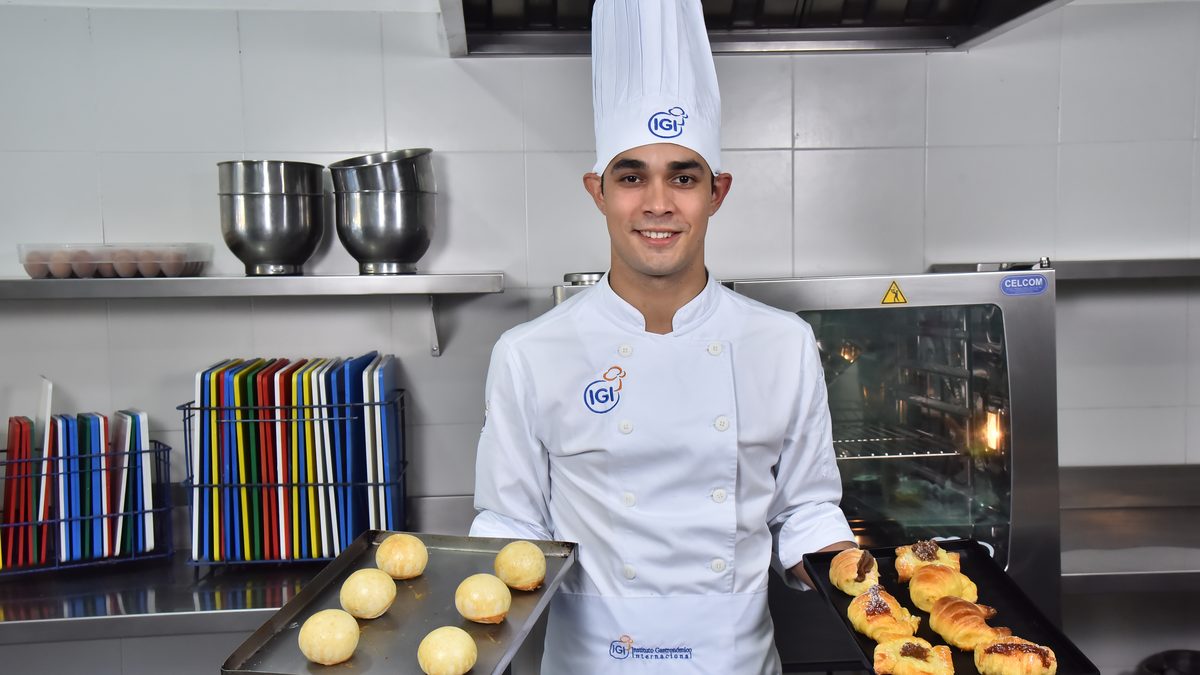 Chef panadero de IGI retirando una bandeja de facturas recién horneadas del horno durante una clase