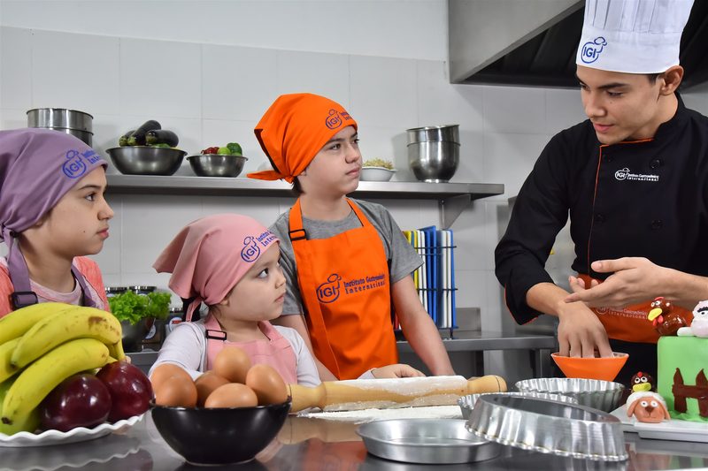 Niños participando de una clase práctica de cocina con un instructor