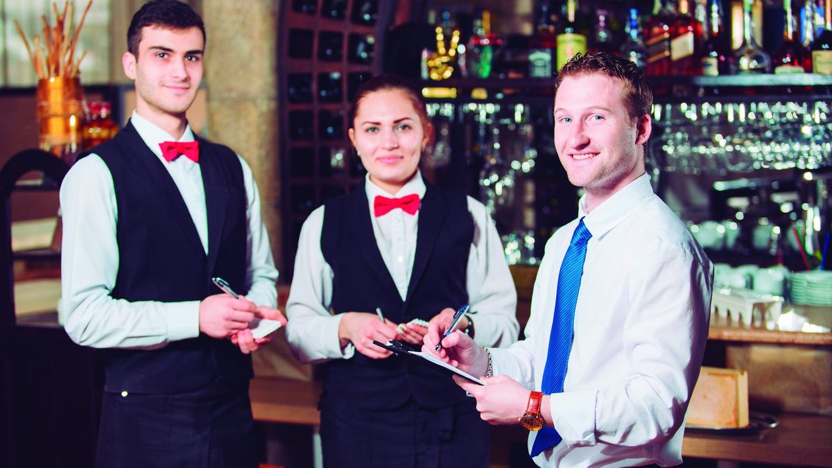 Equipo de servicio de salón preparado para atender un restaurante
