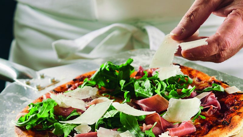 Pizzero profesional estirando masa