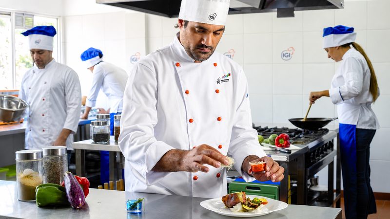 Chef trabajando en una estación organizada mientras el equipo cocina