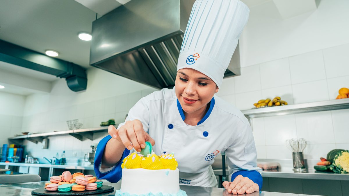Estudiante de IGI decorando una torta durante una práctica de pastelería