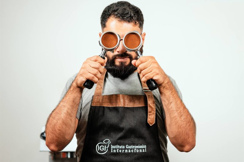 Barista mostrando portafiltros con café molido